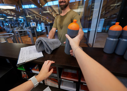 Des mains tendent une gourde à un sportif Des mains tendent une gourde à un sportif